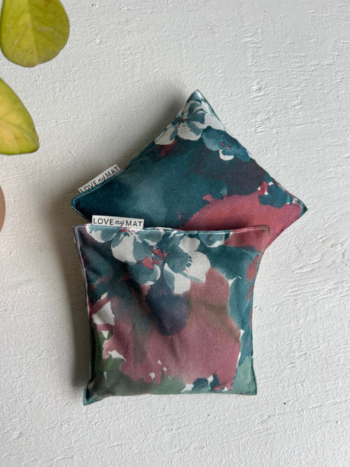 Two floral-patterned yoga knee pillows with 'LOVE AND MAY' branding on a light gray background.