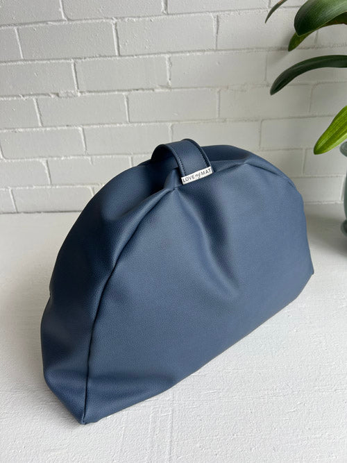 Blue vinyl floor cushion on a white surface with a light gray brick wall background
