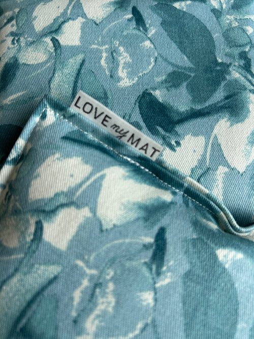 Close-up of a blue floral-patterned fabric knee pillows a 'LOVE my MAT' label.