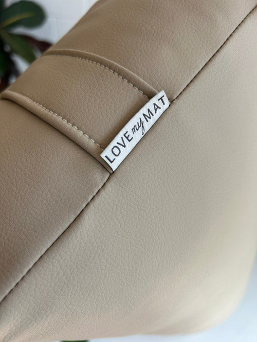 Beige vinyl yoga bolster with a 'LOVE my MAT' label on a white background