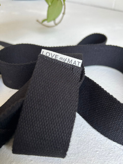 Black yoga mat strap with 'LOVE my MAT' label on a white background