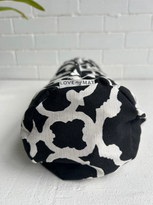 Black and white patterned side view of a yoga mini bolster with 'LOVE my MAT' branding on a light gray background