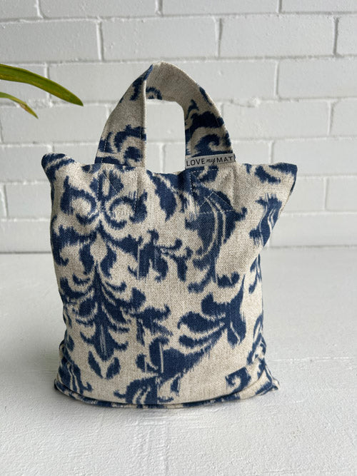 Blue and white patterned sand bag with 'LOVE' and 'MADE' text on a white background