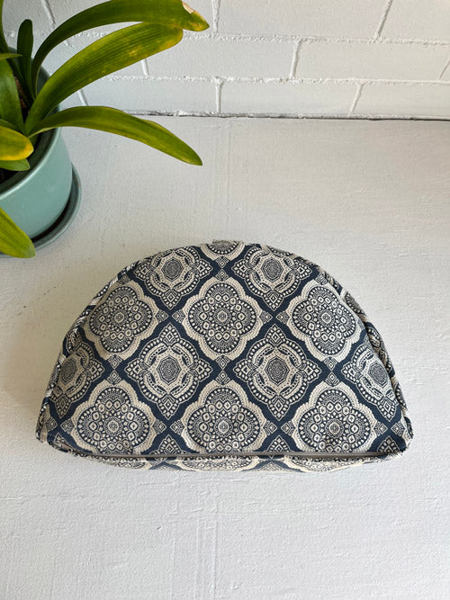 Fabric Meditation floor pillow with geometric pattern on a white surface next to a plant