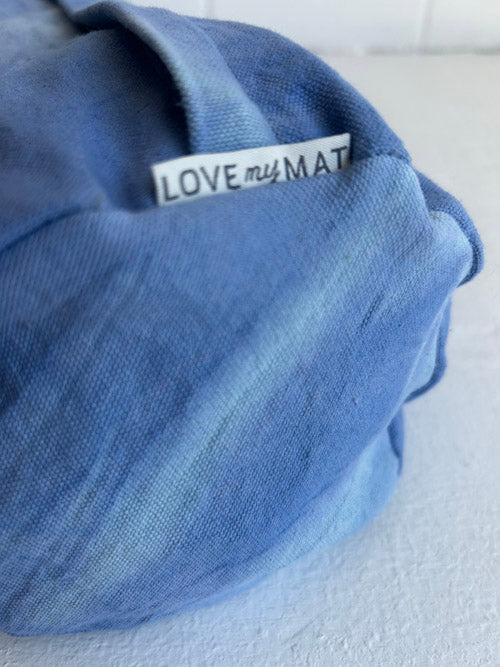 Blue fabric bolster with a 'LOVE my MAT' tag on a white background