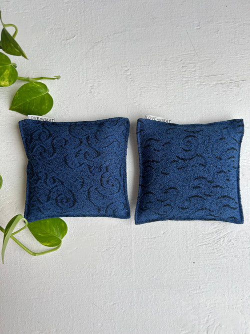 Two blue Yoga knee pain relief yoga cushions with intricate patterns on a white background.