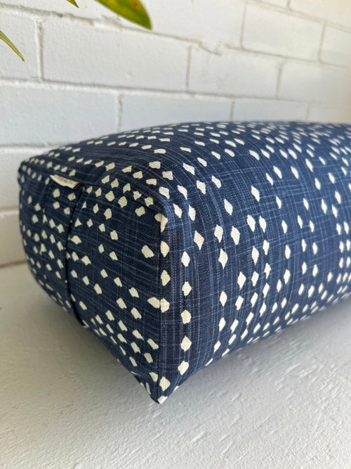 Blue and white end view of a yoga bolster with a white background