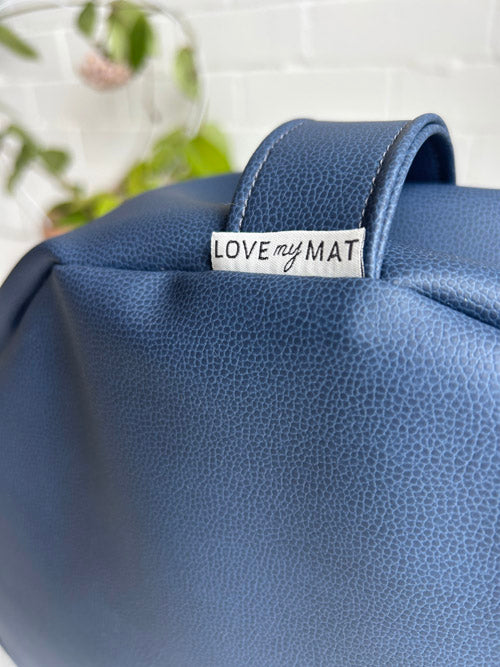 Blue textured cushion with 'Love my Mat' tag on a blurred background