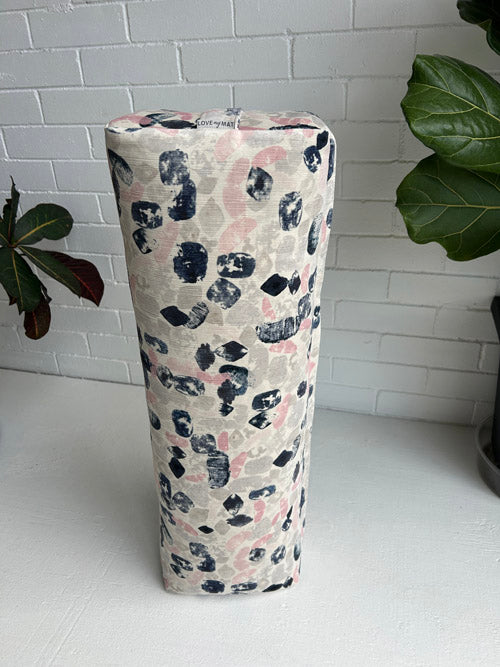 Long Yoga Bolster on a white surface with plants in the background