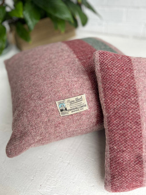Two pink textured pillows with a label on a white surface.