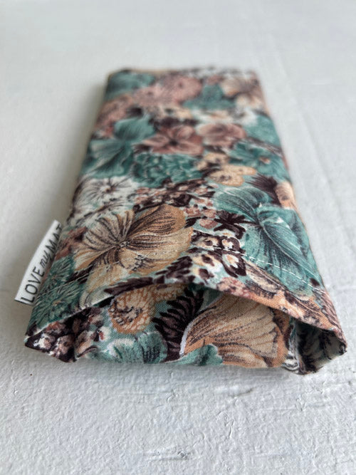 Floral patterned eye pillow insert area with a visible brand tag on a white background