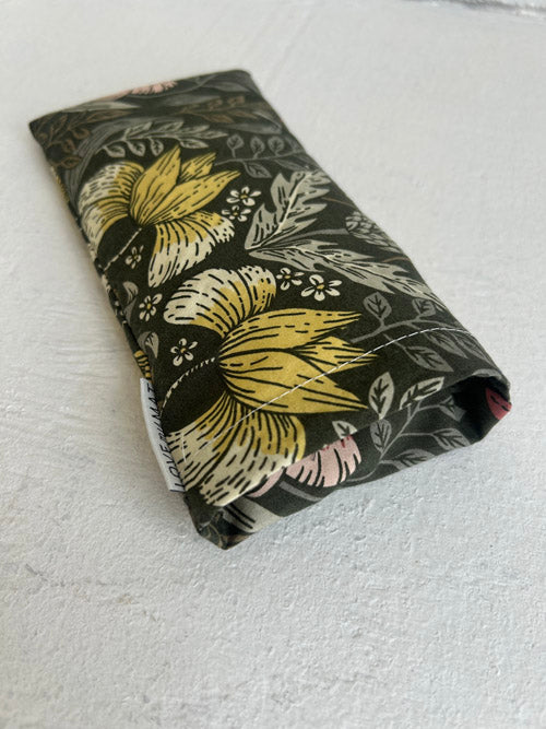 Floral-patterned fabric eye pillow on a textured white surface