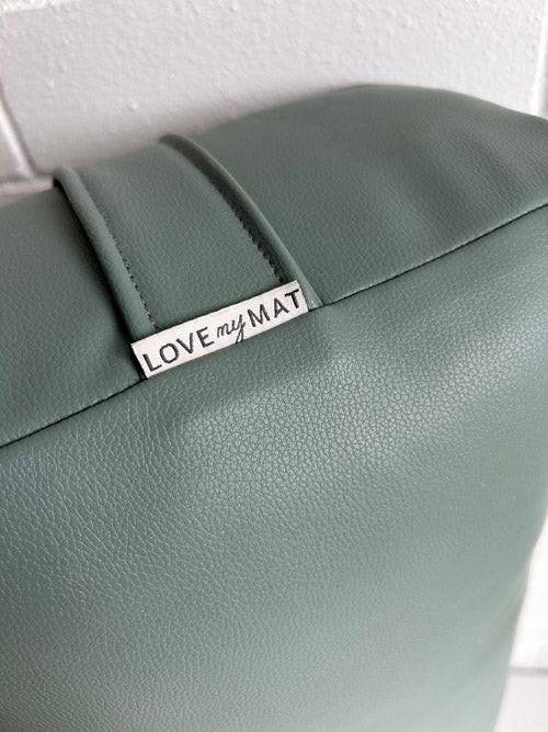 Green vegan leather yoga bolster with a 'LOVE my MAT' tag on a white background