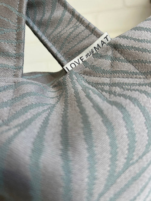 Textile with 'LOVE the MAT' tag on a neutral background