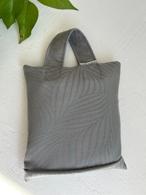 Gray 5lb weighted sandbag with leaf pattern on a white surface