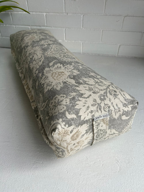 Yoga bolster with floral pattern on a white surface