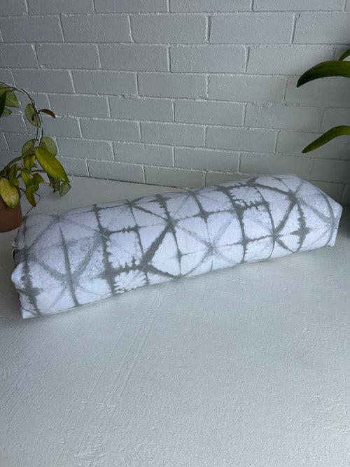  Grey tie-dye patterned long yoga bikster on a white surface with a light gray tiled wall background.