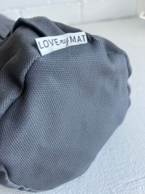Gray textured yoga bolster with 'LOVE my MAT' label on a white surface