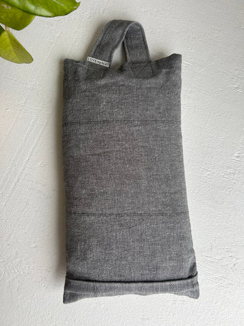 Gray fabric 10lb sandbag with handles on a light gray background