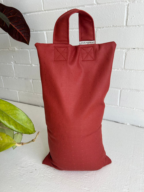 Red sandbag with a visible brand label on a white background