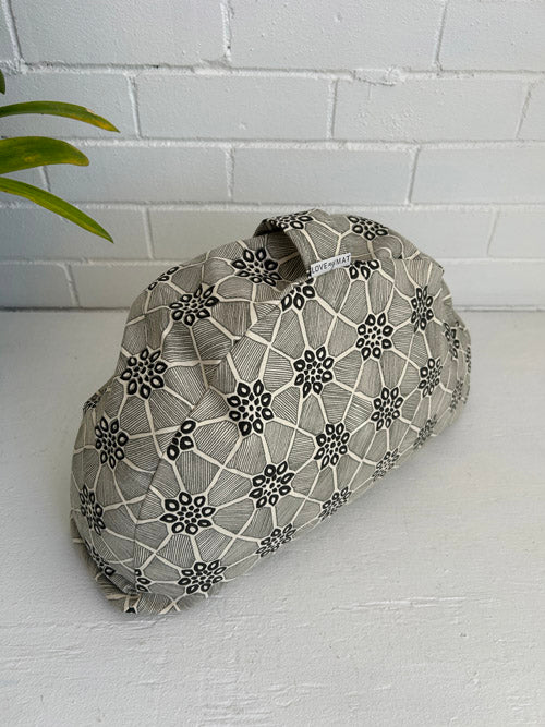 Fabric meditation cushion on a white surface with a white brick wall background