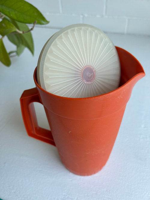 Tupperware lid and pitcher orange with white backgropund