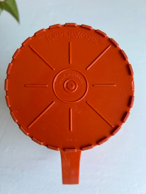 Tupperware logo on orange pitcher with white background