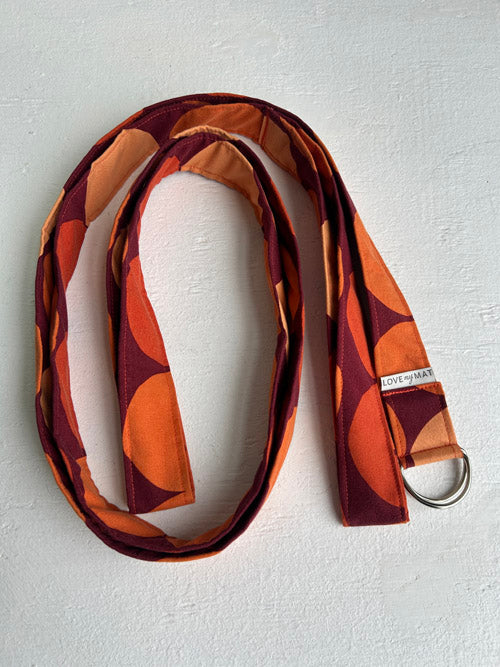 Patterned strap with a metal ring on a light gray background