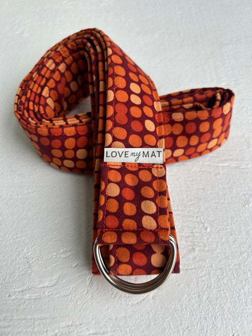 Yoga strap with orange circular pattern and 'LOVE my MAT' label on a white background