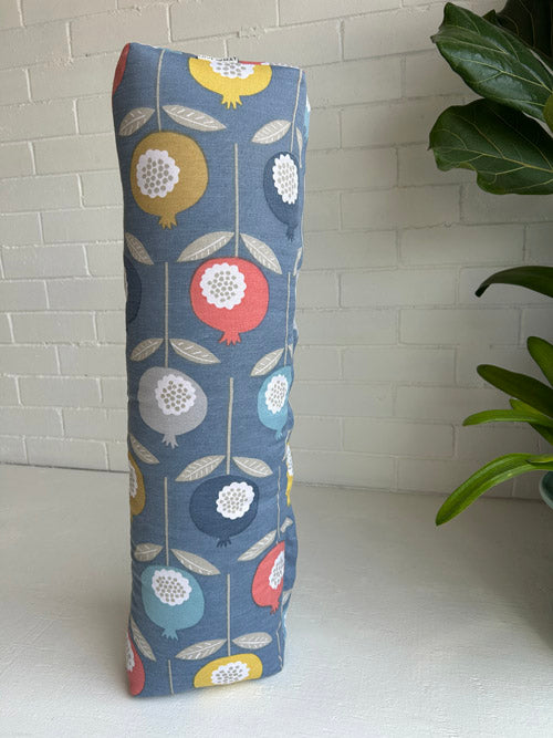Decorative bolster with floral pattern on a white surface