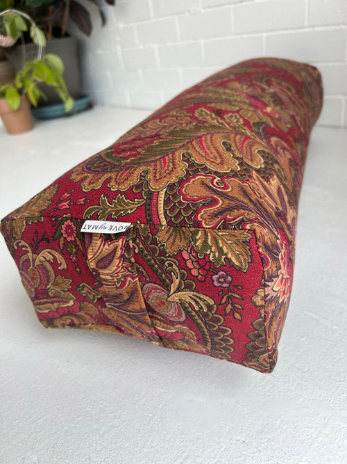 Decorative Yoga Bolster with paisley pattern on a white surface