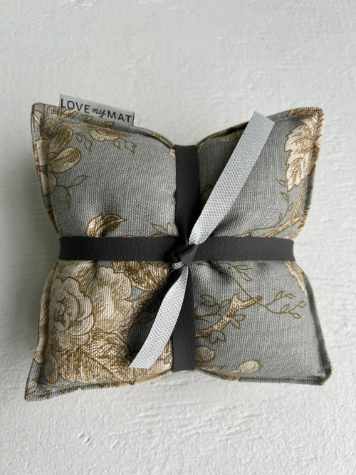 Yoga knee pillows with floral pattern and ribbon on a light background