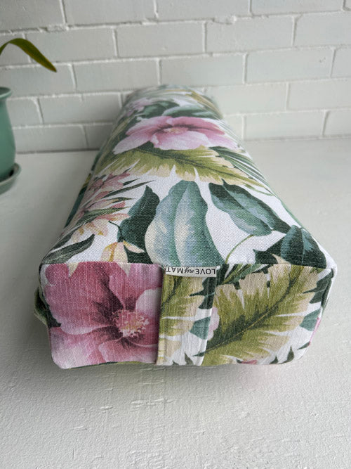 Side Image of a Yoga Bolster in a tropical Floral fabric on a white surface and against a white background
