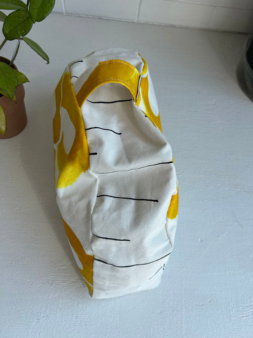 Fabric floor cushion with yellow and white pattern on a light surface