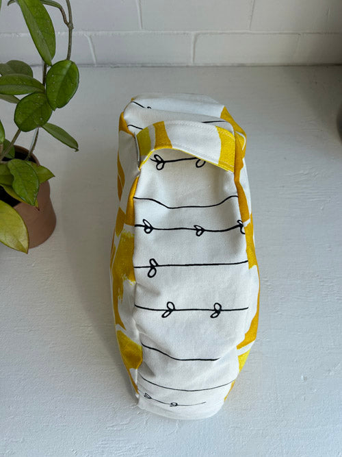 Floral yellow and white patterned meditation cushion on a white surface