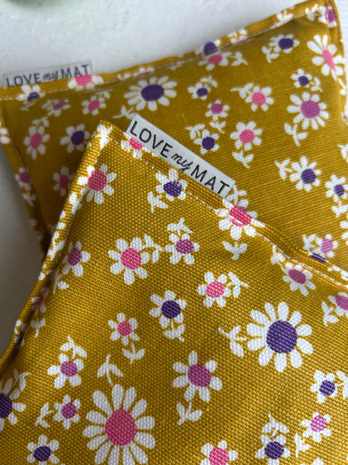 Yellow fabric yoga knee pillows with floral pattern and 'LOVE my MAT' label.