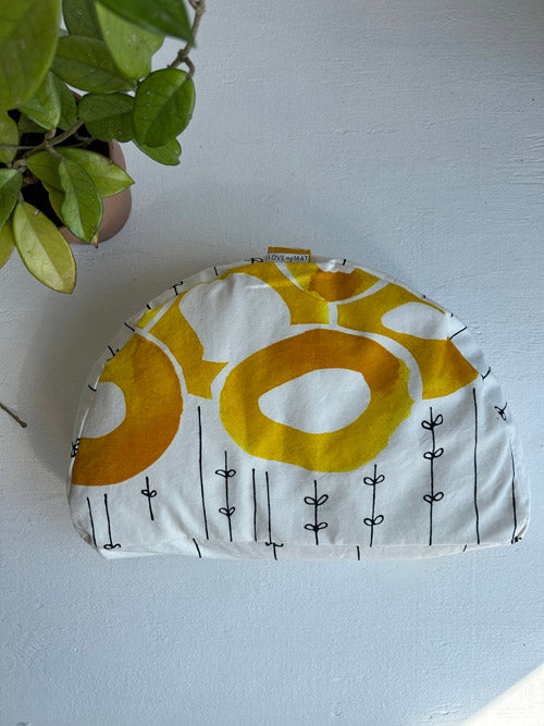Fabric Floor Cushion -yellow and white pattern on a white surface with a plant in the corner.