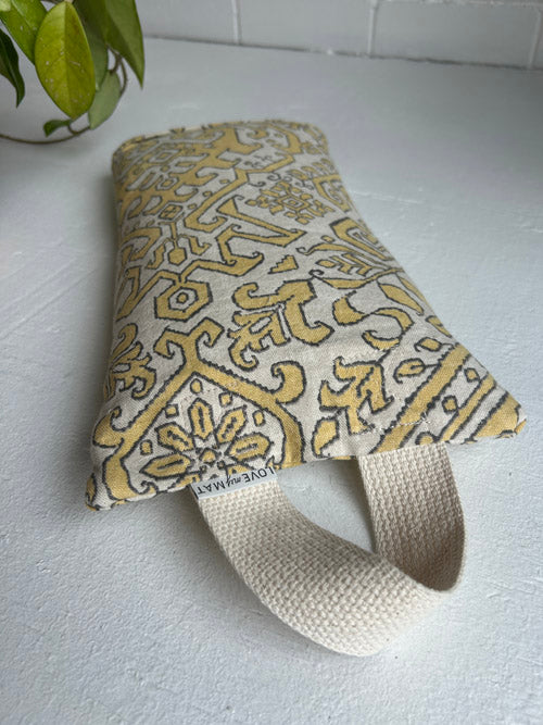 Patterned sandbag with a strap on a white surface