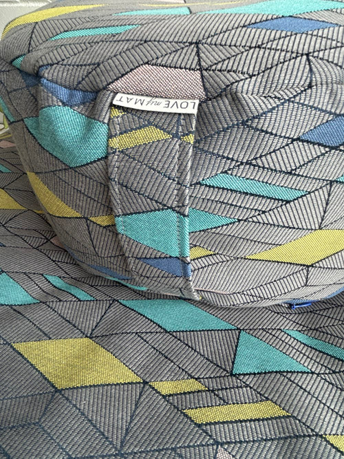 Close-up of a geometric patterned fabric with a visible brand label.